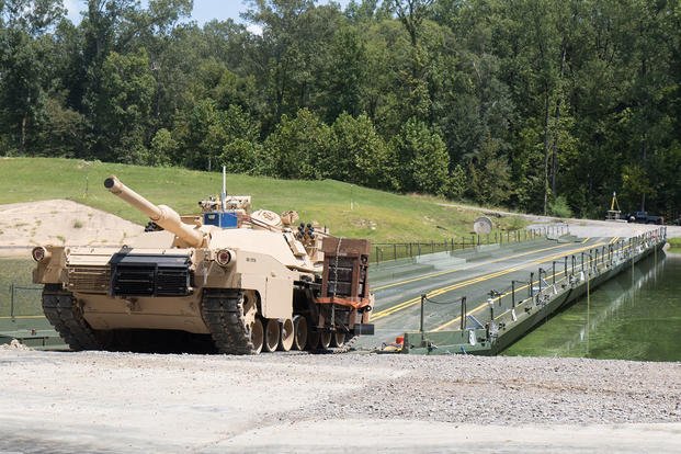 modified M1 Abrams tank  lines up to cross an Improved Ribbon Bridge (IRB)