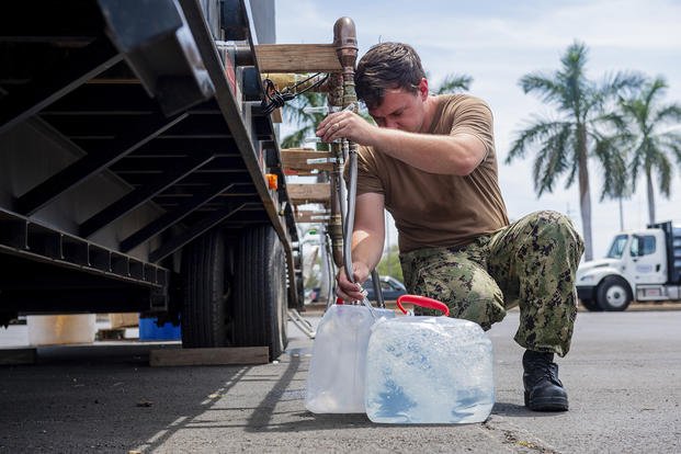 Machinist’s Mate (Nuclear) 2nd Class Joseph Morrissey, assigned to Pearl Harbor Naval Shipyard, fills jugs at a water distribution center servicing Joint Base Pearl Harbor-Hickam residents.