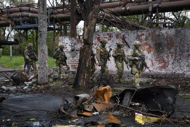 Russian troops walk in a destroyed part of the Illich Iron & Steel Works Metallurgical Plant in Mariupol, in territory under the government of the Donetsk People's Republic, eastern Ukraine.