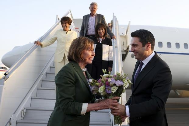 Head of Armenian National Assembly Alen Simonyan, right, hands a bouquet of flowers to Nancy Pelosi 