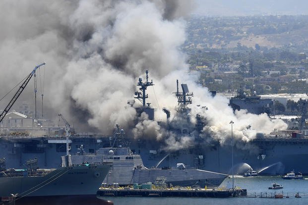 Smoke rises from the USS Bonhomme Richard at Naval Base San Diego after an explosion and fire on board the ship.