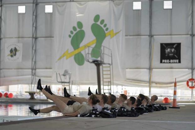Special Warfare Training Wing trainees perform flutter kicks.
