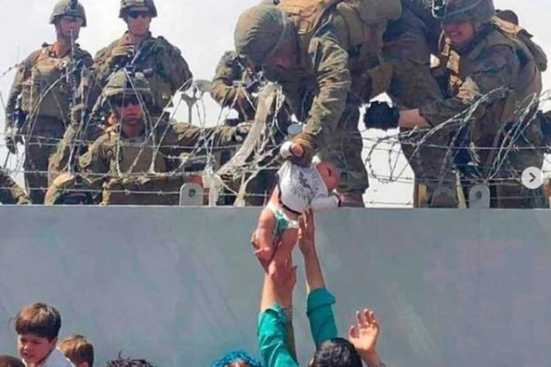 Baby being passed to a U.S. Marine fro evacuation in Kabul.
