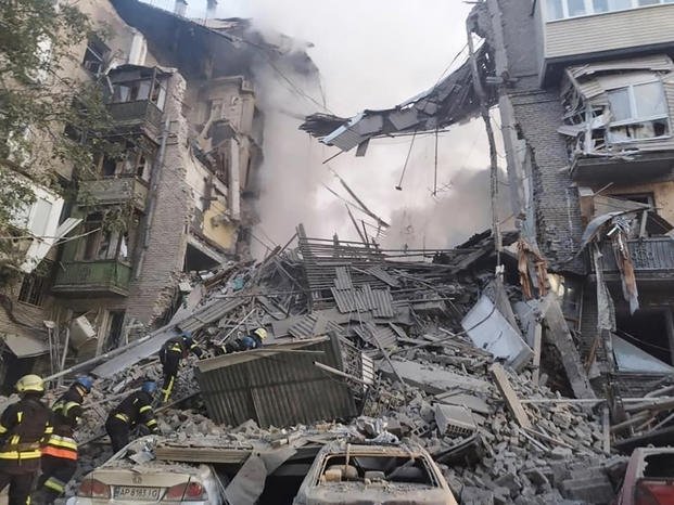 rescuers work at the scene of a building damaged by shelling in Zaporizhzhia, Ukraine