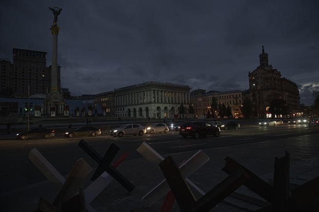 Cars pass in Independence Square at twilight in Kyiv, Ukraine.