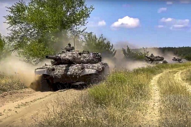 In this handout photo taken from video and released by Russian Defense Ministry Press Service on July 30, 2022, tanks of the 2nd Army Corps of the People's Militia of the Luhansk People's Republic are seen on a mission at an undisclosed location in Ukraine. 