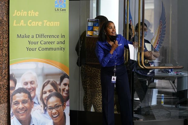Theresa Moore, senior manager or learning experience at L.A. Care Health Plan, calls candidates waiting for interviews for health care positions at the L.A. Care Health Plan job fair at the company's office in downtown Los Angeles on Saturday, May 21, 2022. 