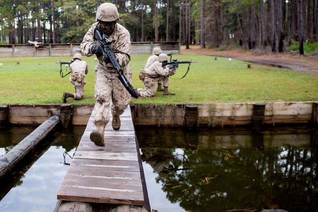 A U.S. Marine Corps recruit runs over a bridge during The Crucible