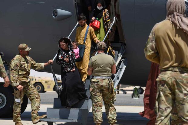 Afghan evacuees leave a U.S. C-17 Globemaster.