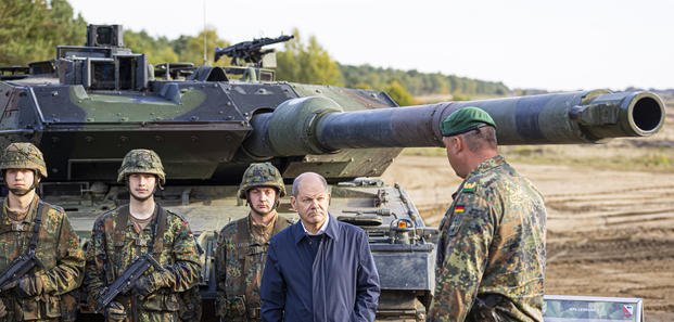 German Chancellor Olaf Scholz stands with German army Bundeswehr soldiers at a "Leopard 2" main battle tank
