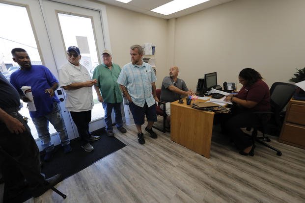 Laid-off workers line up for job searches at a temporary office of the Louisiana Employment Commission.