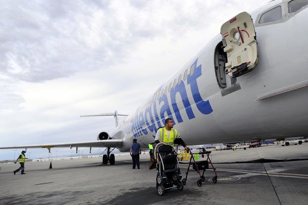 Ramp agent Vince Divon retrieves gate-checked items after the Allegiant Air jet parked at McCarran International Airport in Las Vegas.