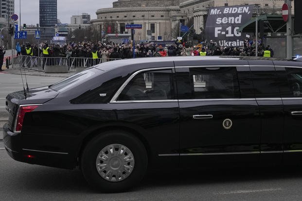 Protestors, rear, hold a sign asking U.S. President Joe Biden to send fighter jets to the Ukraine