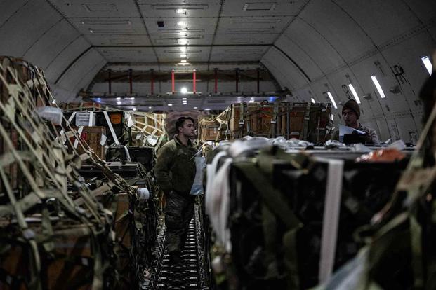 Airmen check cargo logs during a security assistance mission at Dover AFB.
