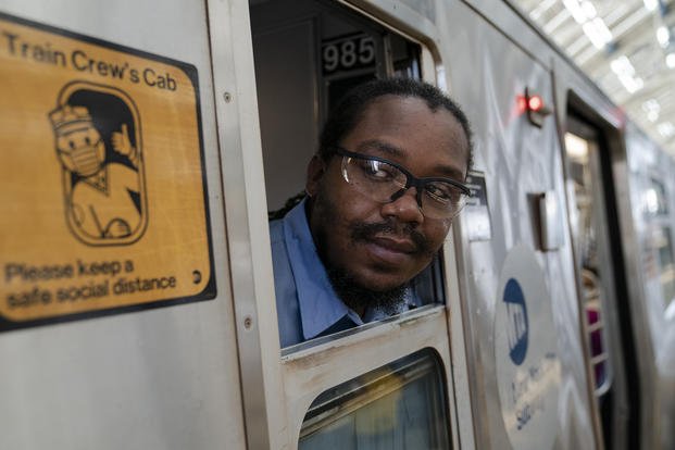 Metropolitan Transportation Authority conductor Desmond Hill checks the platform for late riders attempting to board the train as he works the N subway line from Brooklyn's Coney Island to Queen's Astoria-Ditmars neighborhoods in New York.