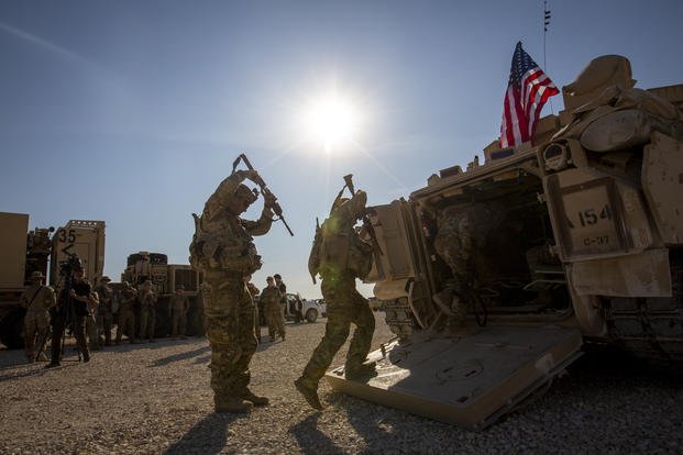 Crewmen enter Bradley fighting vehicles at a US military base in Northeastern Syria