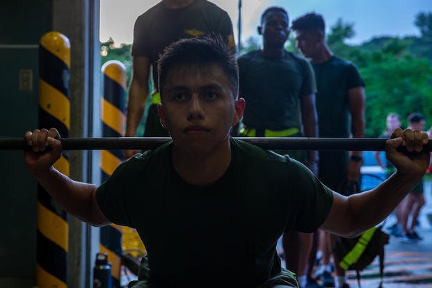 U.S. Marine Corps Lance Cpl. Isai Guevara, an embark specialist with Headquarters and Services Company, 3d Landing Support Battalion, Combat Logistics Regiment 3, 3d Marine Logistics Group, squats during the Lander Trials on Camp Foster in Okinawa, Japan.