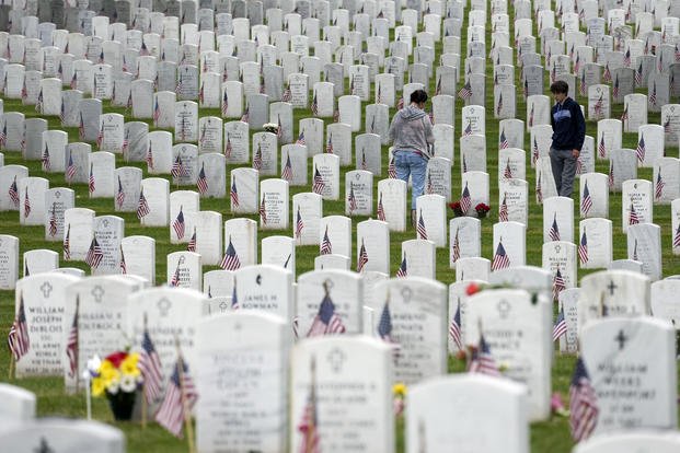 People walk among the headstones as they visit Section 60 at Arlington National Cemetery.