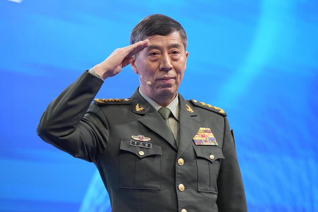 Chinese Defense Minister Li Shangfu salutes before delivering a speech.