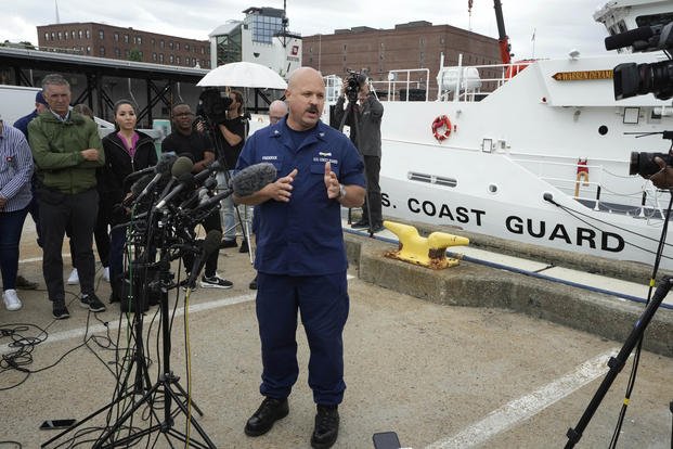 U.S. Coast Guard Capt. Jamie Frederick, center, faces reporters