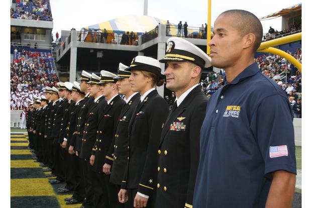Sottosessuale di 1a classe David Goggins, operatore di guerra speciale, è all'attenzione con i membri della squadra di triathlon della US Naval Academy