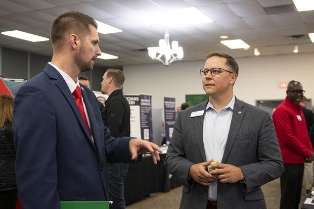Air Force veteran Logan Brooks (left) asks Lucas Draper of First Command Financial about career opportunities during the Hiring Our Heroes Job Fair at Wright-Patterson Air Force Base, Ohio.