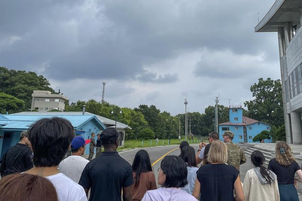 tourists stand near a border station at Panmunjom in the Demilitarized Zone in Paju