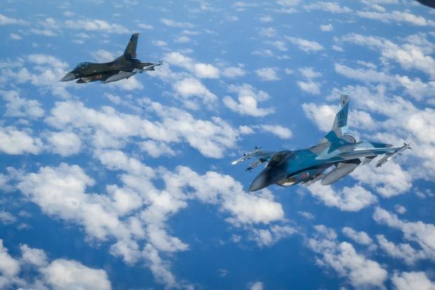 Two U.S. Air Force F-16 Fighting Falcons fly over the Pacific Ocean.
