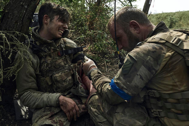 A soldier of Ukraine's 3rd Separate Assault Brigade gives first aid to comrade