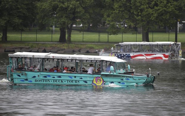 Duck boats make their way along the Charles River