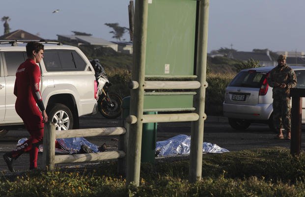 two South Africa Navy personnel lay covered after being recovered from the sea at Kommetjie, near Cape Town