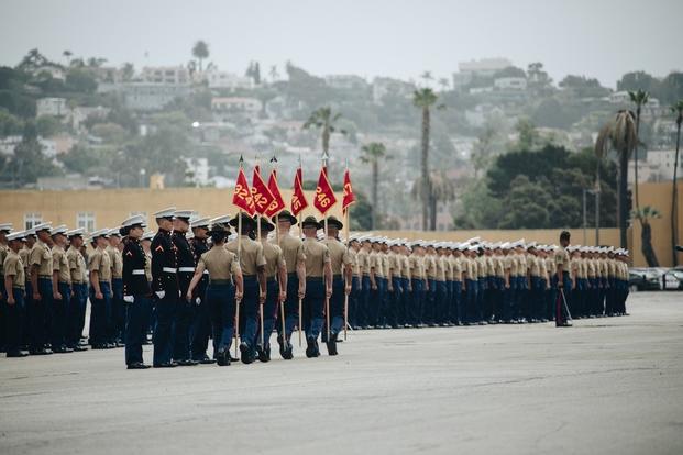 U.S. Marine Corps drill instructors with Lima Company, 3rd Recruit Training Battalion, take the series guidons from the platoon guides during the Lima Company graduation ceremony aboard Marine Corps Recruit Depot San Diego, May 6, 2021. 