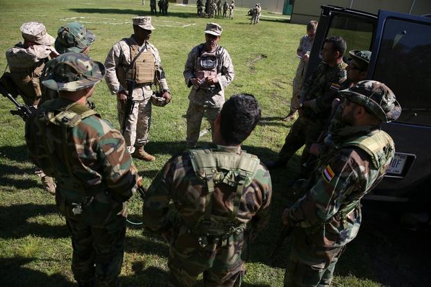 Members of the advise and assist team from 2nd Marine Expeditionary Force train a group of foreign role-players on vehicle search procedures during a three-day mission support exercise aboard the Naval Air Station Oceana Dam Neck Annex.