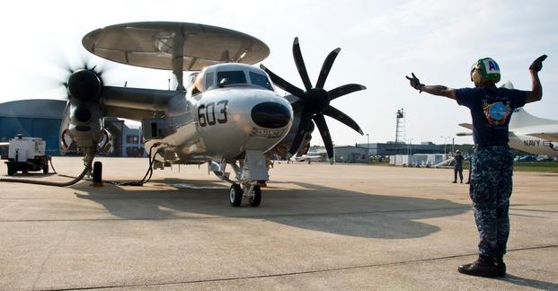 U.S. Navy Aviation Structural Mechanic 2nd Class Colin Nicome signals for the start up of an E-2D Hawkeye aircraft assigned to Air Test and Evaluation Squadron (VX) 1 at Naval Air Station Patuxent River, Md., Aug. 27, 2013.