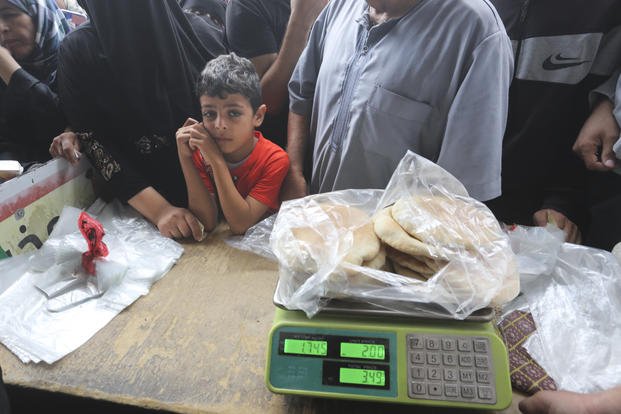 Palestinians wait to buy bread during the ongoing bombardment of the Gaza Strip.