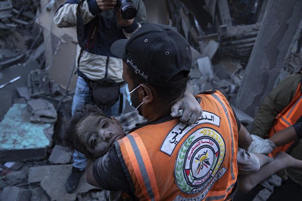 Palestinians evacuate wounded from a building destroyed in Israeli bombardment in Khan Younis