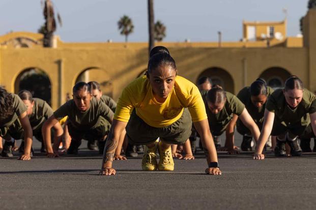 Senior Marine Corps drill instructor leads her platoon in warm-up exercises