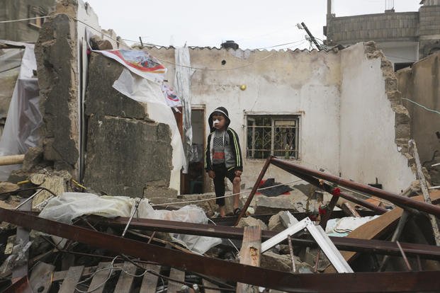 A Palestinian boy stands among the destruction after Israeli strikes on Rafah, Gaza Strip