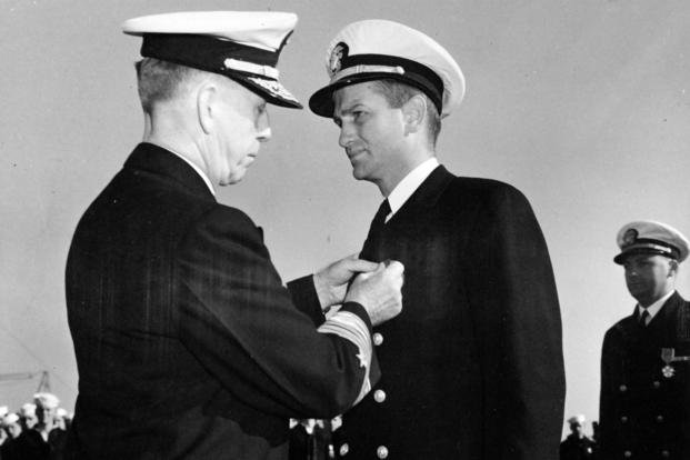Adm. Royal E. Ingersoll, commander in chief of the Atlantic Fleet, pins the Navy Cross on USS Borie Lt. Charles Hutchins on the flight deck of the USS Card. 