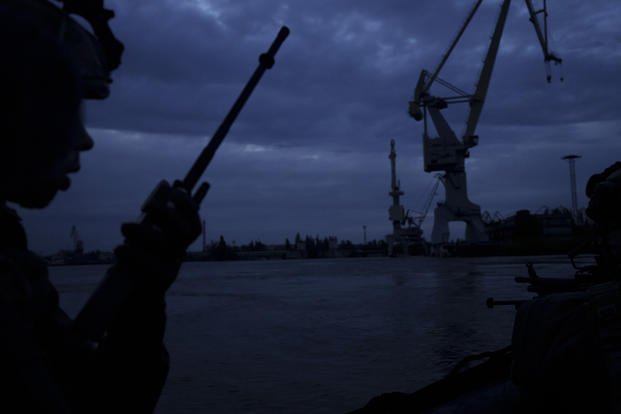 A Ukraine Special Operations Forces officer talks on the radio while navigating the Dnipro River during a night mission in Kherson region, in Kherson, Ukraine.