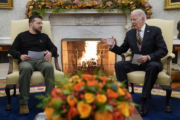 President Joe Biden reaches out to shake hands with Ukrainian President Volodymyr Zelenskyy