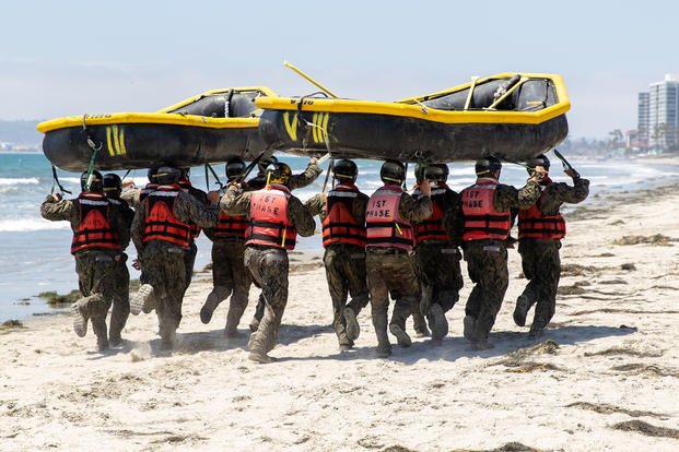 U.S. Navy SEAL candidates run with inflatable boats on their heads during the ‘Hell Week’ crucible of Basic Underwater Demolition/SEAL (BUD/S) training on Naval Amphibious Base Coronado, California. 
