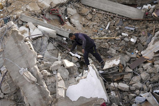 A Palestinian looks at the destruction after an Israeli strike.