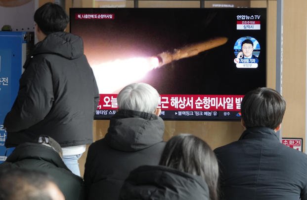 A TV screen shows a file image of North Korea's missile launch.
