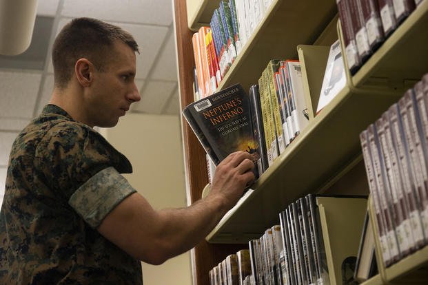 A Marine puts a book back on a  shelf at Marine Corps Base Quantico, Virginia.