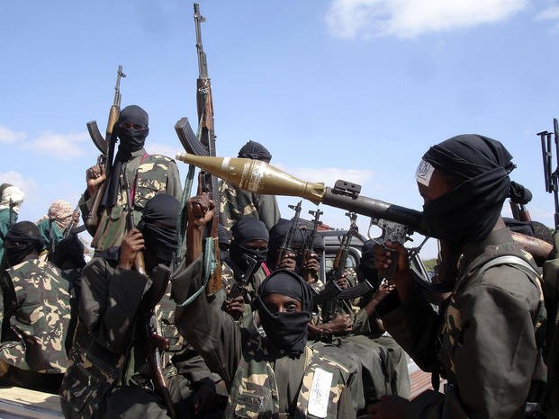Armed al-Shabab fighters ride on pickup trucks.