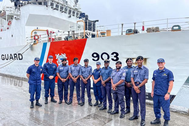 U.S. Coast Guard and Fiji Navy personnel stand in front of the U.S. Coast Guard Cutter Harriet Lane