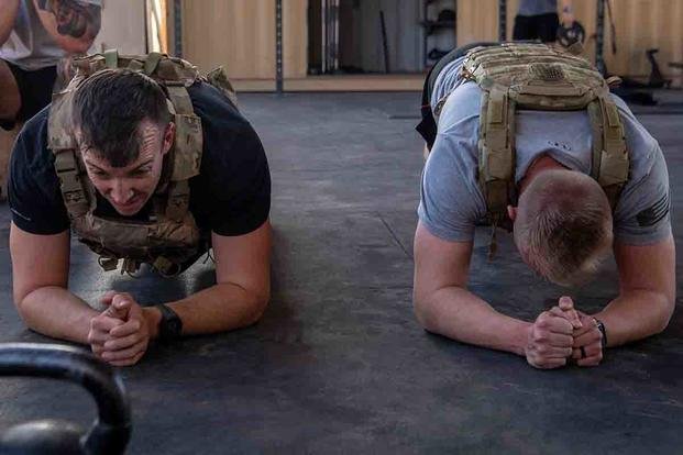 U.S. Air Force Master Sgt. Kevin McCarthy, left, and 1st Lt. Andrew Braafhart hold a 30-second plank during the 137 Memorial Workout Challenge at Air Base 201, Niger, February 2024. The memorial workout is held annually across the globe to honor the lives of the 137 explosive ordnance disposal service members who have lost their lives since the beginning of the war on terrorism. (U.S. Air Force/Tech. Sgt. Rose Gudex)