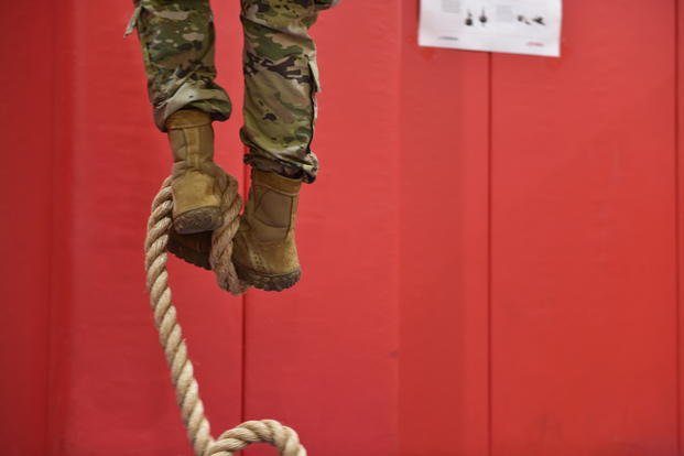 A 911th Security Forces Squadron patrolman shows airmen rope climbing leg lockout techniques during an Air Assault School assessment.