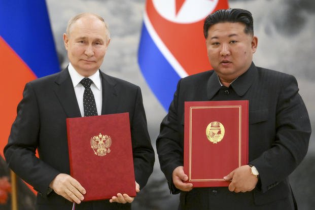 Russian President Vladimir Putin, left, and North Korea's leader Kim Jong Un pose